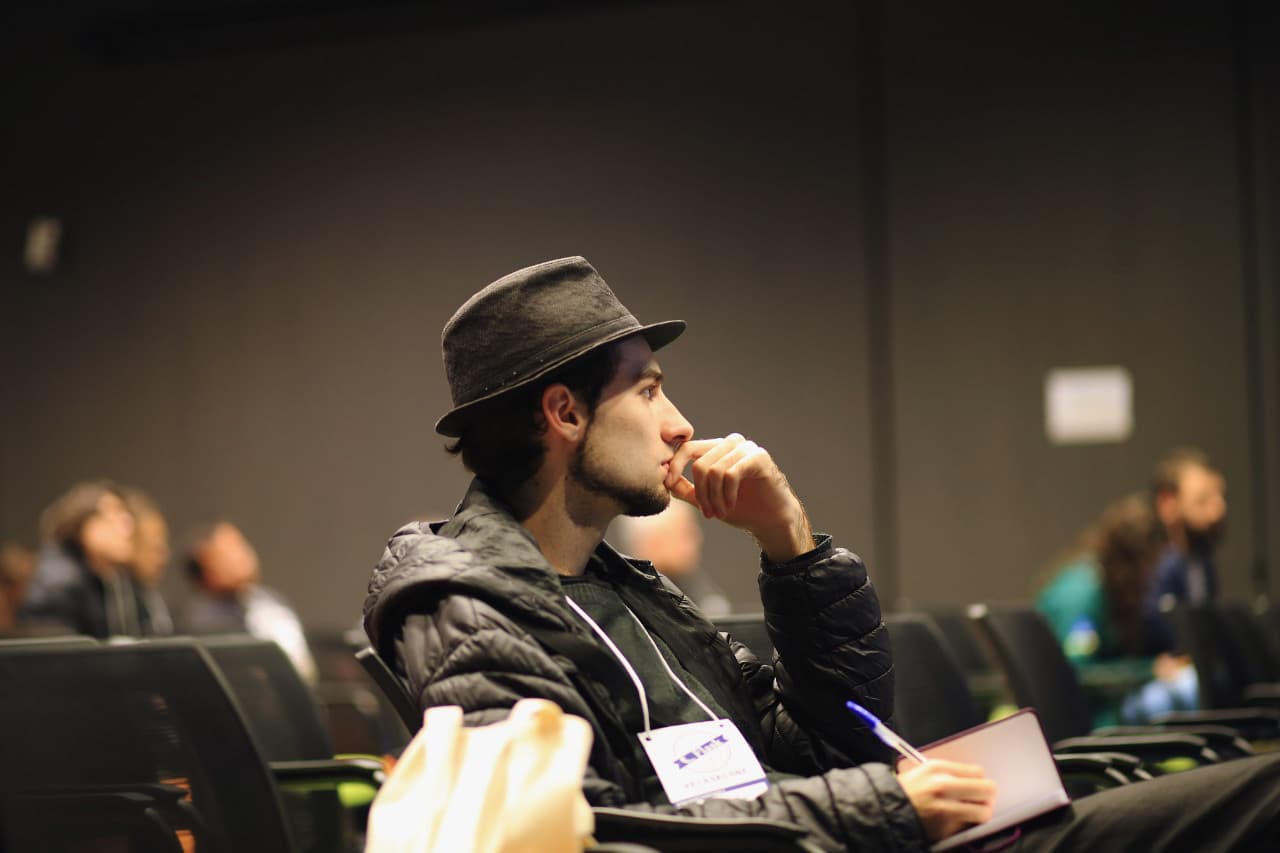 In the audience, notebook open
